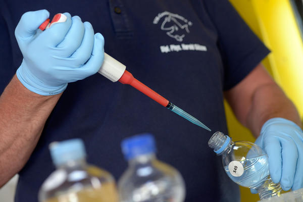 Harald Gülzow entnimmt einer Flasche eine Probe